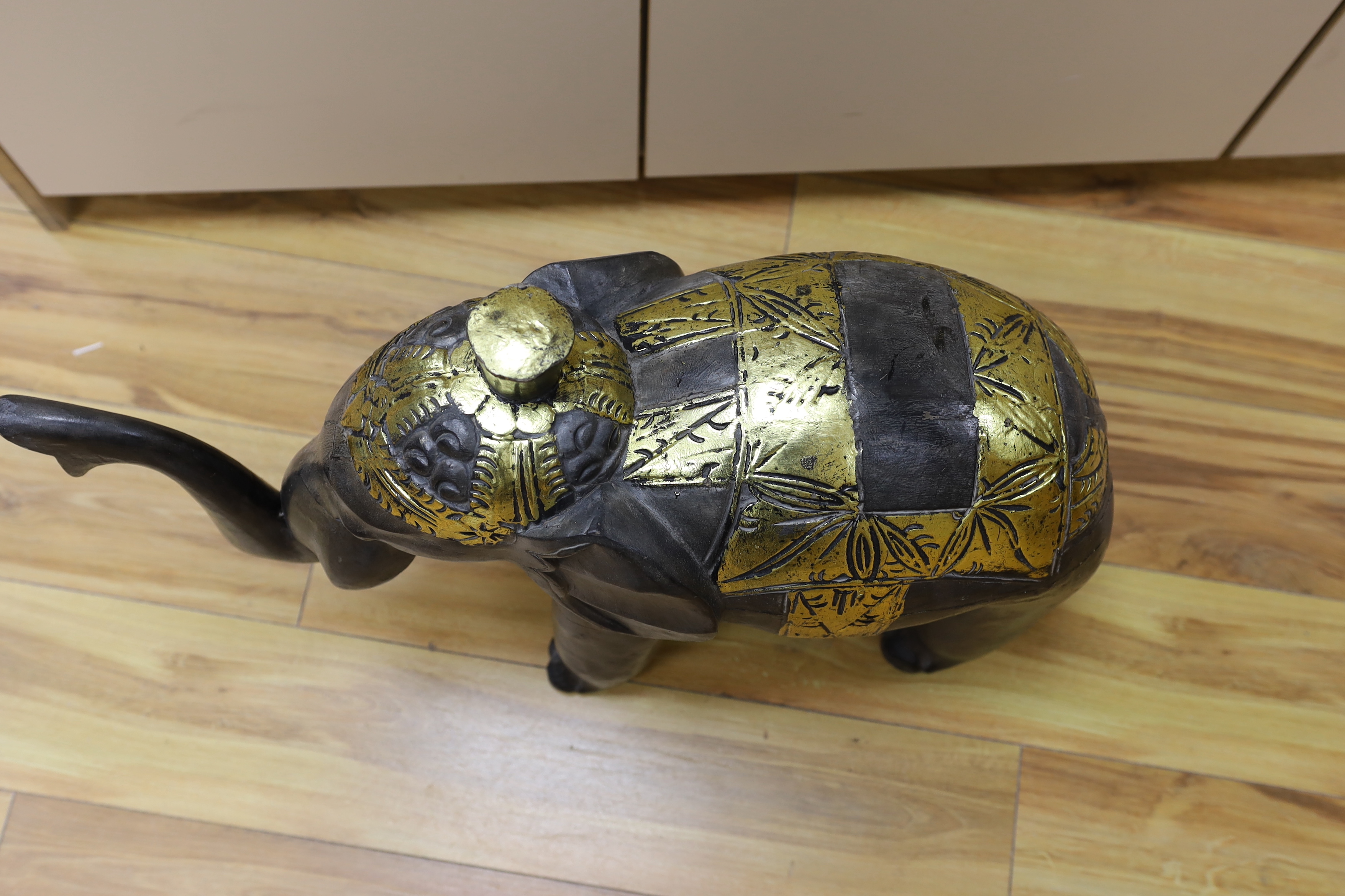 A carved Indian elephant, decorated with gilt decoration, 49cm high